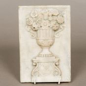 A 19th century carved marble or alabaster tablet Modelled with a flowering twin handled urn with a