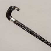 A Ceylonese carved ebony walking stick Fitted with a silver collar,