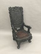 A late 19th/early 20th century Chinese carved hardwood open armchair The panelled back centred with