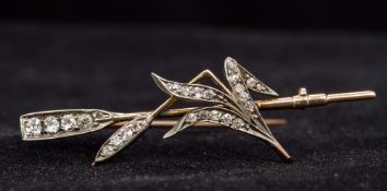 An unmarked gold diamond set bar brooch Formed as an oar amongst a reed. 4.25 cm wide.