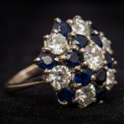 An 18 ct white gold diamond and sapphire cluster ring Of flowerhead form,
