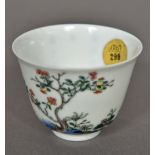 A Chinese Kangxi famille verte porcelain tea bowl Finely painted with a flowering shrub opposing