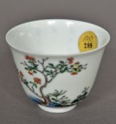 A Chinese Kangxi famille verte porcelain tea bowl Finely painted with a flowering shrub opposing