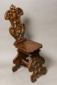 A 19th century carved walnut Sgabello chair The shaped back worked with a vacant heraldic shield,