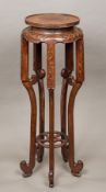 A 19th century Chinese carved hardwood urn stand The dished circular top above the carved frieze,