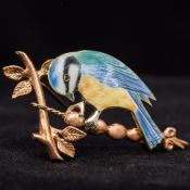 A 9 ct gold enamel decorated brooch Formed as blue tit on a branch. 5 cm wide.