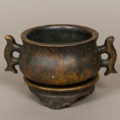 A Chinese patinated bronze censer on stand Of squat waisted circular form, with twin loop handles,