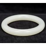 A Chinese mutton fat jade bangle Of typical form. 8 cm diameter.