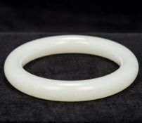 A Chinese mutton fat jade bangle Of typical form. 8 cm diameter.