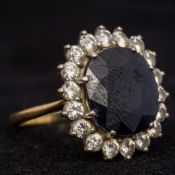 A sapphire and diamond set ring The central stone facet cut.
