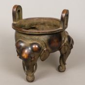 A large Chinese patinated bronze censer Of squat circular form, with twin loop handles,