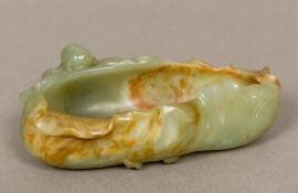 A Chinese carved jade brush washer Formed as a small boy climbing on a side of a leaf. 13.