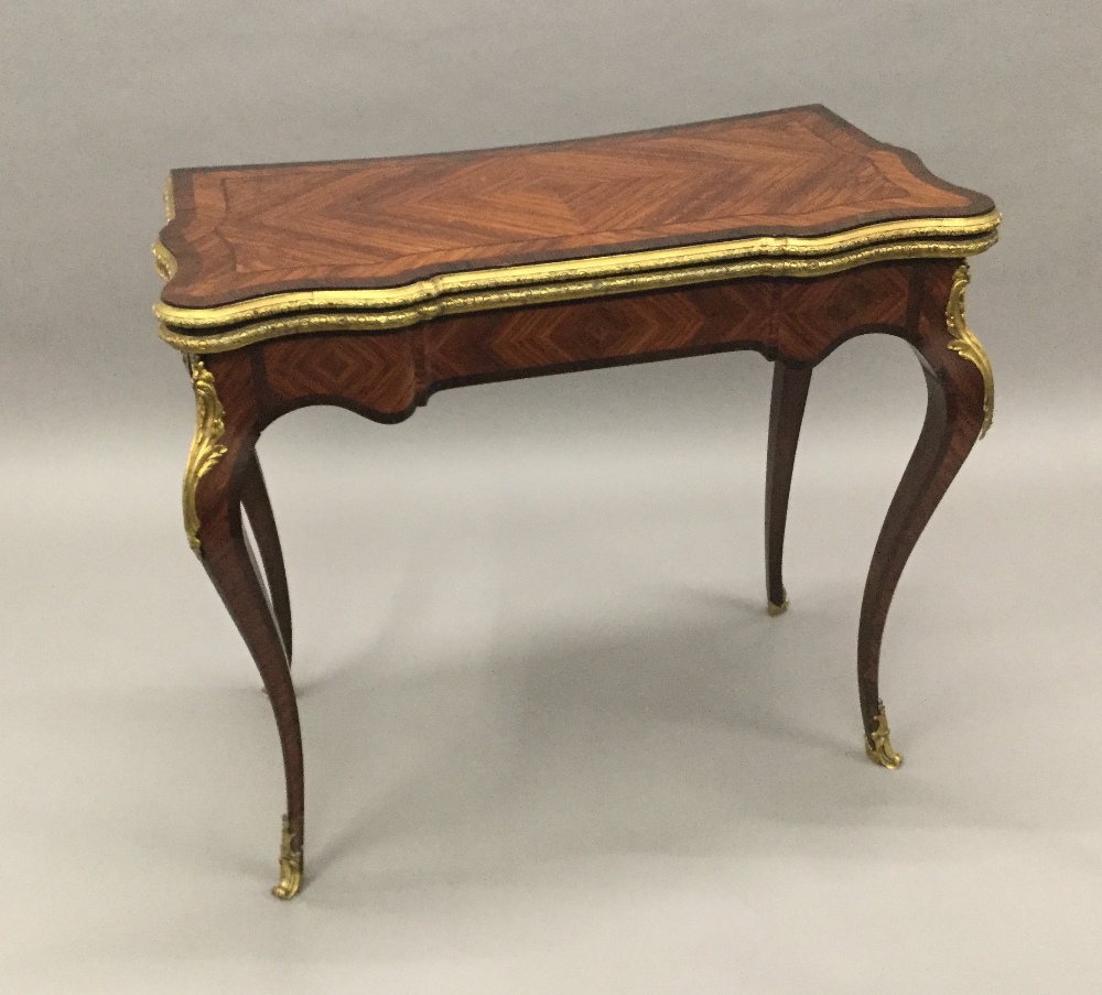 A 19th century gilt bronze mounted kingwood card table The shaped hinged rectangular top enclosing