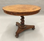 A 19th century pollard oak tilt-top tripod table The circular top above the barley twist column and