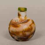 A Chinese carved agate snuff bottle Carved in the round with horses and floral sprays. 7 cm high.