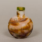 A Chinese carved agate snuff bottle Carved in the round with horses and floral sprays. 7 cm high.