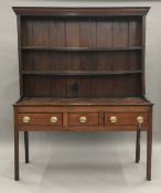 An 18th century and later oak dresser The rack with moulded cornice above two fixed shelves and