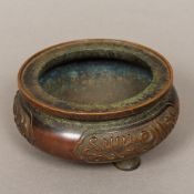 A Chinese patinated bronze censer Of three legged squat circular form,