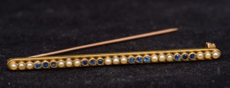 A 15 ct gold sapphire and seed pearl set bar brooch 6.5 cm long.