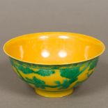 A Chinese porcelain bowl Decorated with figures in a continuous gardenscape, on a yellow ground,