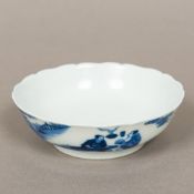 A Chinese blue and white porcelain shallow bowl With wavy rim and decorated in the round with