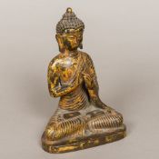 A gilt bronze model of Buddha Typically modelled seated in the lotus position. 23 cm high.