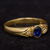 An 18 ct gold diamond and sapphire ring The central facet cut sapphire flanked by two small