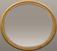 A large 19th century gilt framed wall glass The oval bevelled plate within a moulded frame.