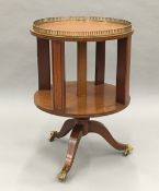 An Edwardian inlaid satinwood revolving etagere/bookcase The circular top with pierced brass
