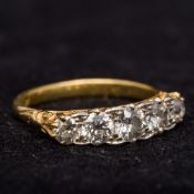 An 18 ct gold five stone diamond ring Of typical form with pierced scrolling shoulders.