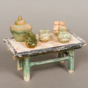 An antique Chinese Tang type pottery model of a table Set with various accoutrements. 29 cm long.