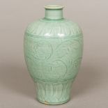 A Chinese porcelain vase Of baluster form, with incised decoration on a celadon ground. 21 cm high.