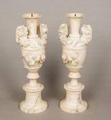 A pair of 19th century alabaster vases Each of twin handled form with carved floral decorations.