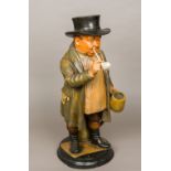 A 19th century painted terracotta figure of a country gentleman Smoking a pipe and drinking ale