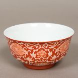 A Chinese porcelain bowl Decorated with lotus strapwork on a red ground,