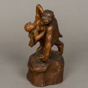 A carved wooden group Modelled as a large ape carrying off a scantily clad woman,