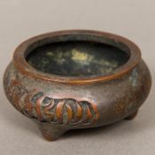 A small Chinese patinated bronze censer Of squat circular three footed form,