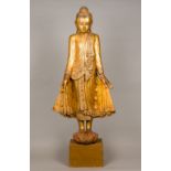 A large 19th century carved giltwood figure of Buddha Modelled standing wearing a headdress and