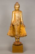 A large 19th century carved giltwood figure of Buddha Modelled standing wearing a headdress and