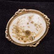 A Regency unmarked gold framed brooch Centred with a cut paper floral design set with seed pearls.