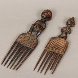 Two African carved and stained wood combs Each figurally mounted.