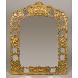 A large late 19th/early 20th century Continental repousse brass framed strut mirror Decorated with