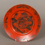 A 19th century Chinese porcelain plate The iron red ground decorated with a floral border