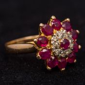 An 18 ct gold diamond and ruby ring Of domed flowerhead form. 1.5 cm diameter.
