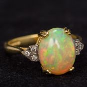 An 18 ct gold diamond and opal ring The central cabochon opal flanked by the diamond set pierced