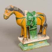 An antique Chinese Tang type pottery horse Typically modelled with green and ochre glaze. 32.