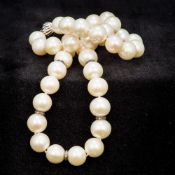 A pearl bead necklace Set with five diamond set spacers. 44 cm long.