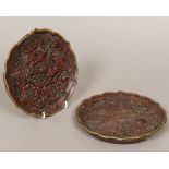 A pair of Chinese cinnabar lacquer on bronze plates Each deeply worked with various figures in
