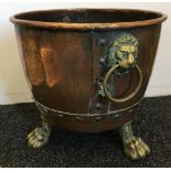 A 19th century copper twin handled cauldron With studded decoration and lion mask ring handles,