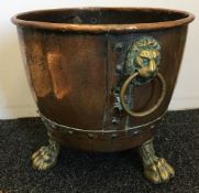 A 19th century copper twin handled cauldron With studded decoration and lion mask ring handles,